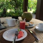 breakfast table with fruit, coffee, and coconut at Bali Purnati