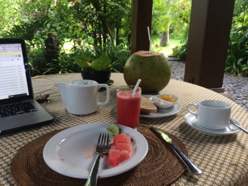 breakfast table with fruit, coffee, and coconut at Bali Purnati