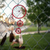 Dreamcatcher hanging on fence outside a blurred image of "Scaffold" exhibit